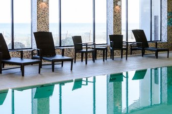 Leere Liegestühle stehen um ein leeres Schwimmbecken