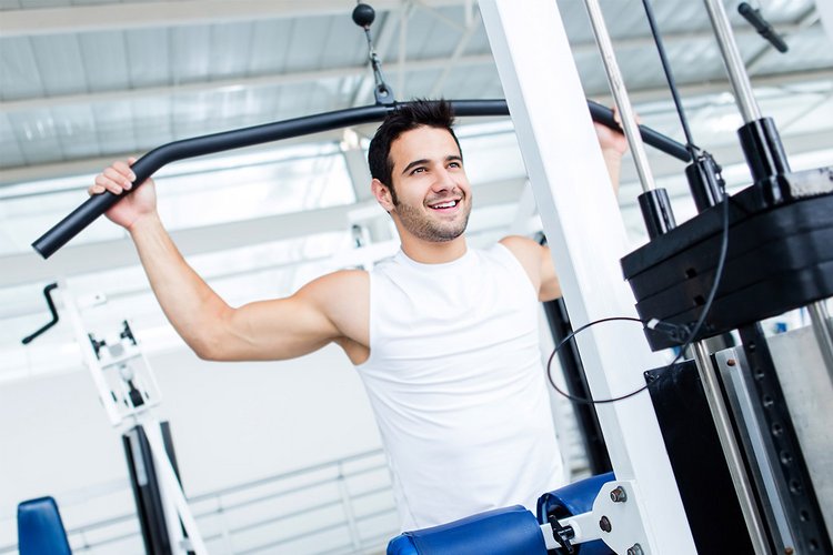 Ein junger Mann steht in einem Fitnessraum