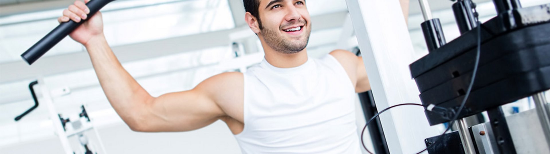 Ein junger Mann steht in einem Fitnessraum